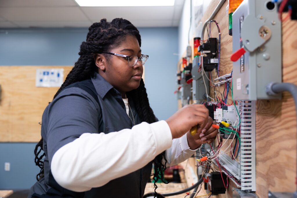 Student in a hands-on training lab learning how to become an electrician at Centura College.