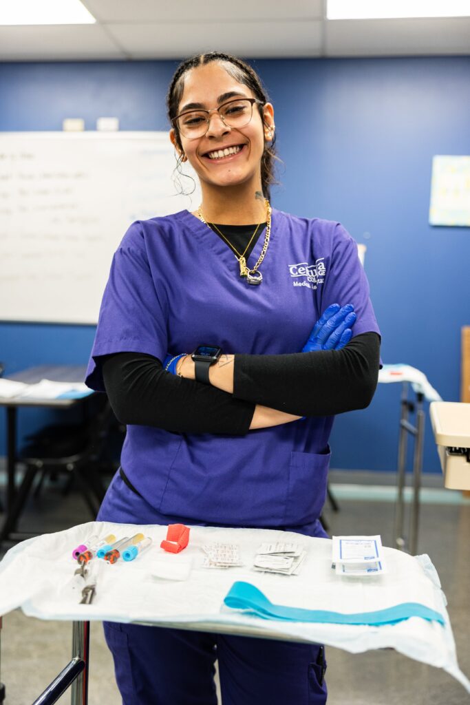 Centura College student in scrubs learning hands-on skills in a medical assistant program, highlighting the value of medical assistant tuition.