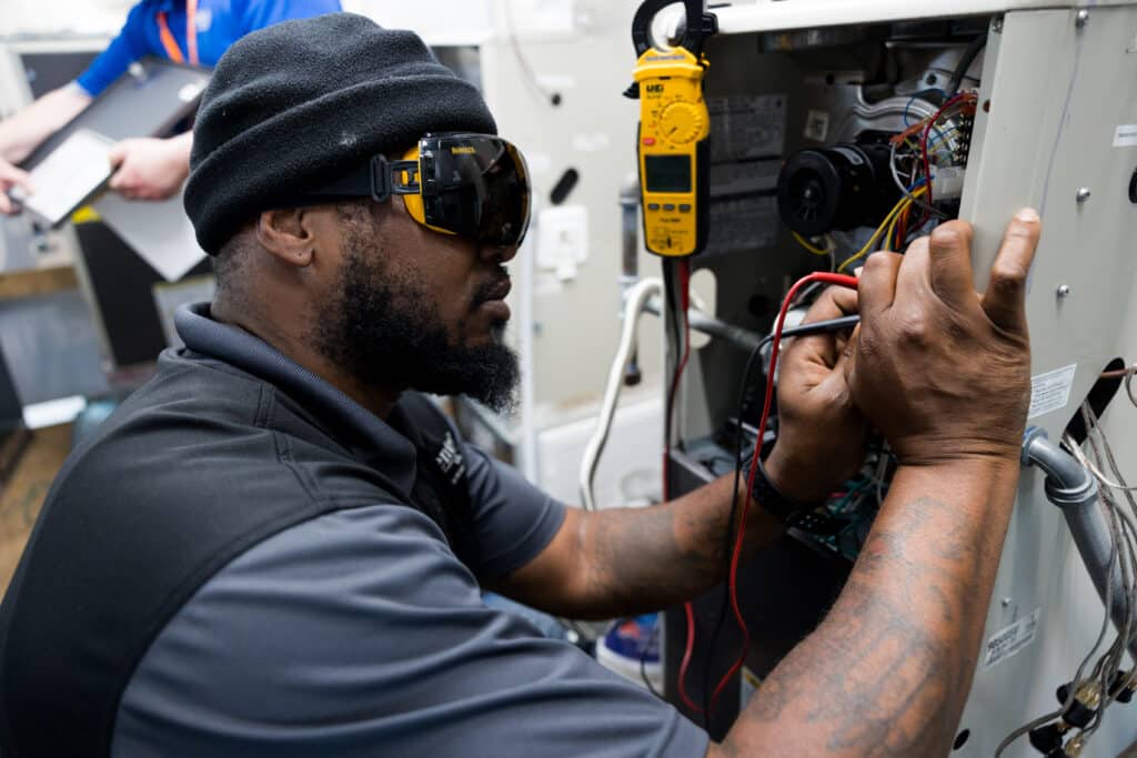 Centura College HVAC student working on heating and cooling equipment