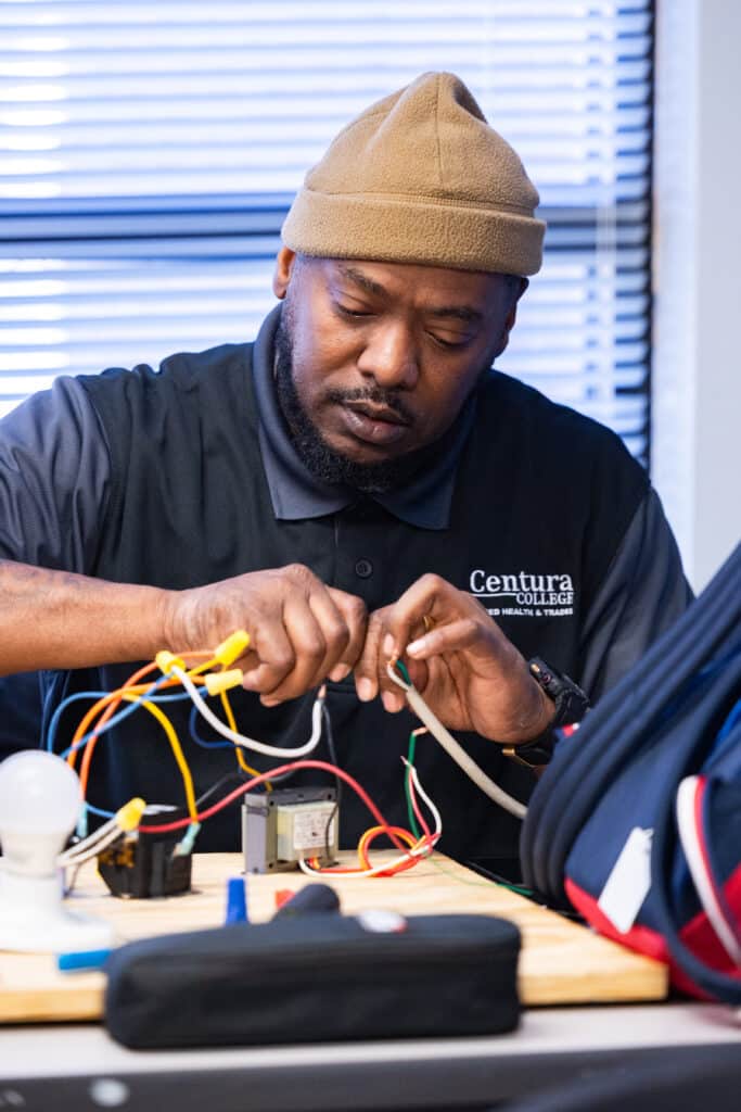 Centura College HVAC student inspecting equipment during training